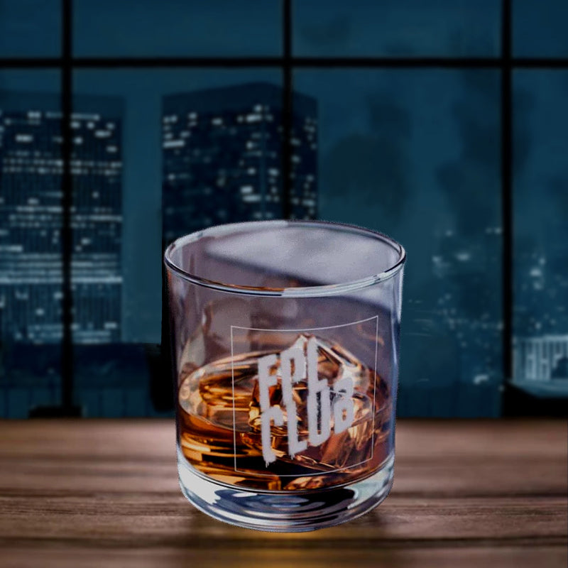 Glass of whiskey with 'FPL CLUB' engraving on a wooden surface with a cityscape background