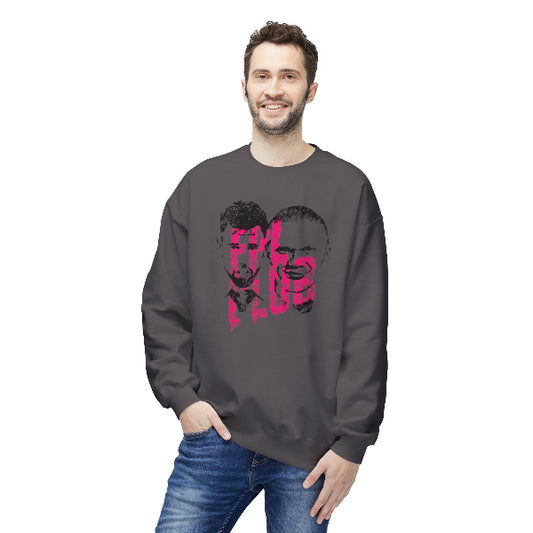A man wearing a dark gray crewneck sweatshirt with a pink and black graphic print on the front, paired with blue jeans, against a plain white background.
