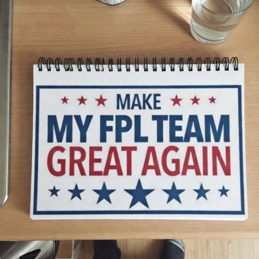 Notebook with 'Make My FPL Team Great Again' text on a wooden table.
