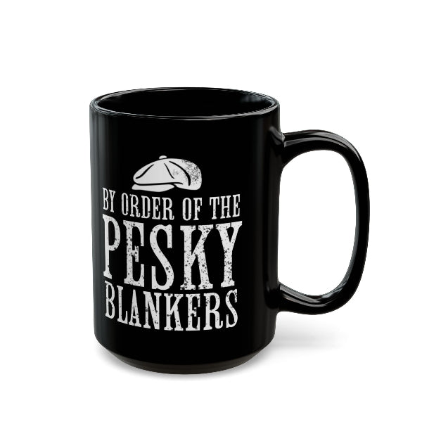 A black ceramic mug with a white distressed typographic design reading 'BY ORDER OF THE PESKY BLANKERS' and a small cap illustration, shown on a clean white background.