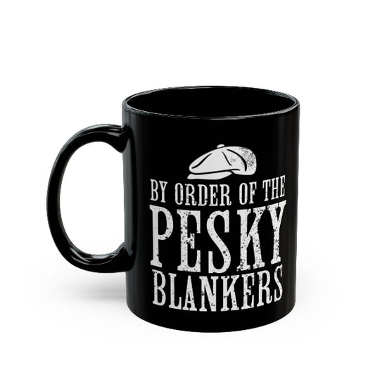 A black ceramic mug with a white distressed typographic design reading 'BY ORDER OF THE PESKY BLANKERS' and a small flat cap graphic above the text, shown on a plain white background.