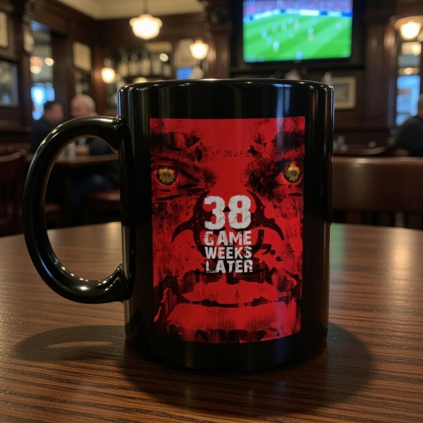 Black mug with red graphic and text '38 Game Weeks Later' on a wooden table.