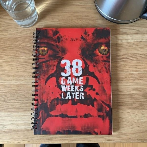 Notebook with a red cover featuring a wolf's face and text on a wooden surface.