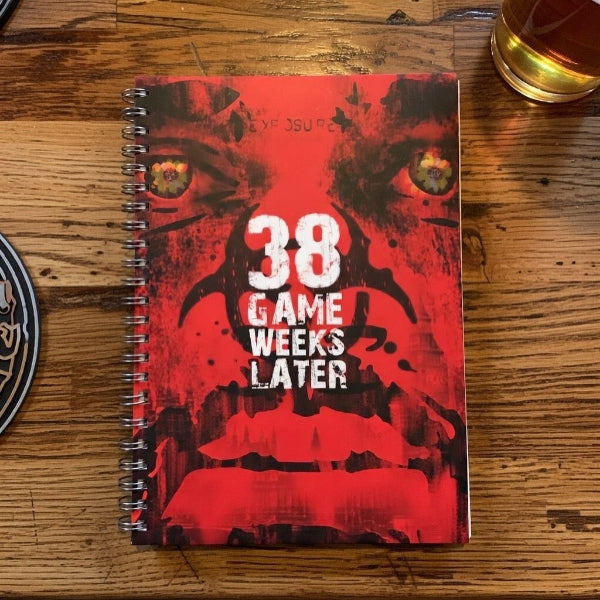 Notebook with a red cover featuring a graphic design and text on a wooden surface