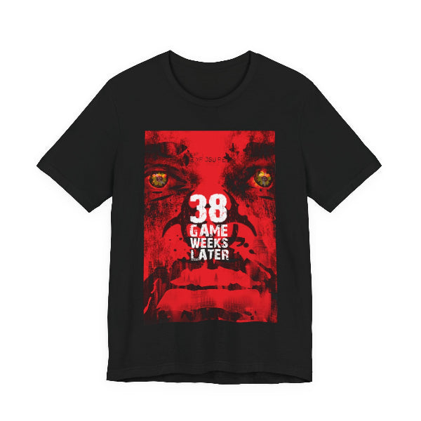 A black short-sleeve crewneck t-shirt featuring a large red graphic print on the front with a stylized face, yellow eyes, and the text '38 GAME WEEKS LATER'.