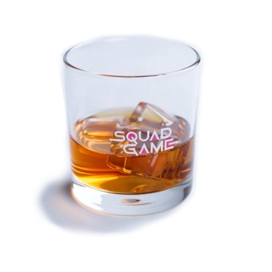 Clear glass with ice cube labeled 'Squad Game' filled with whiskey on a white background