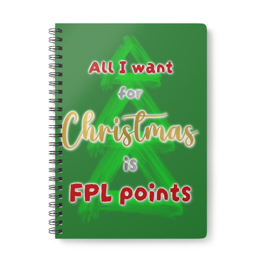 A spiral-bound notebook with a green cover featuring a Christmas tree graphic and the text 'All I want for Christmas is FPL points' in red, gold, and white lettering.
