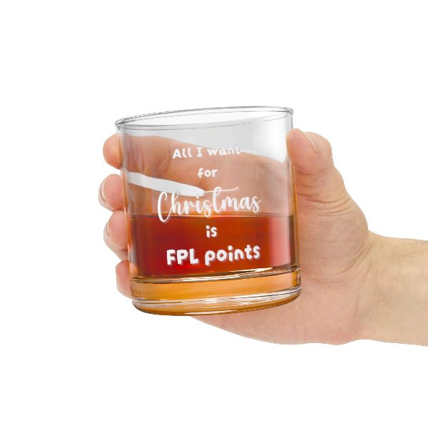 Hand holding a clear glass mug with text, filled with a red liquid.