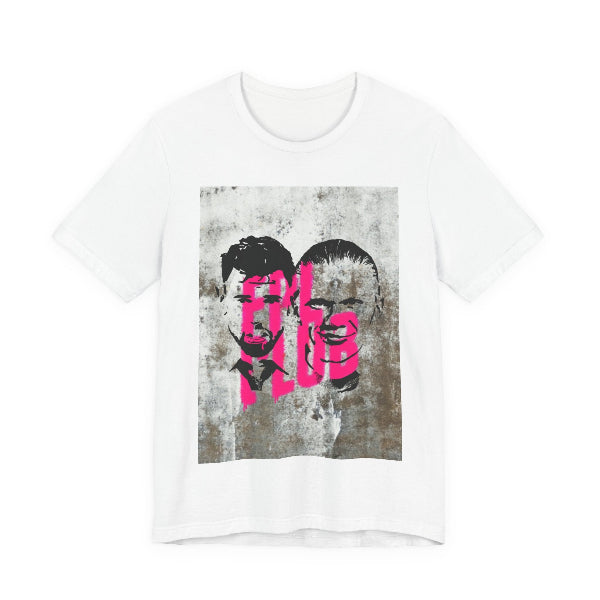 A white short-sleeve crewneck t-shirt featuring a rectangular graphic print on the front. The graphic displays a distressed, grunge-style portrait of two men's faces in black and gray, overlaid with the word 'FUEL' in a vibrant hot pink graffiti font.