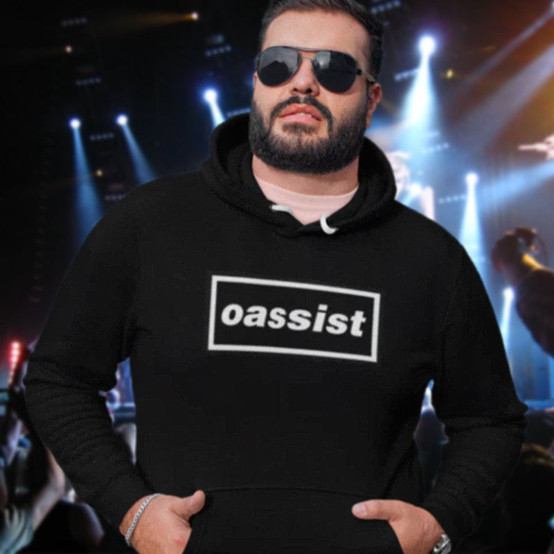 Man wearing a black hoodie with 'oassist' logo in a concert setting