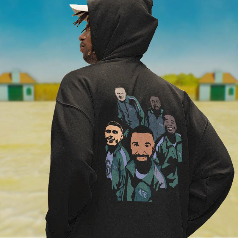 Person wearing a black hoodie with graphic designs on the back, standing in an outdoor setting.