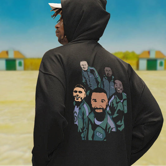 Person wearing a black hoodie with graphic designs on the back, standing in an outdoor setting.