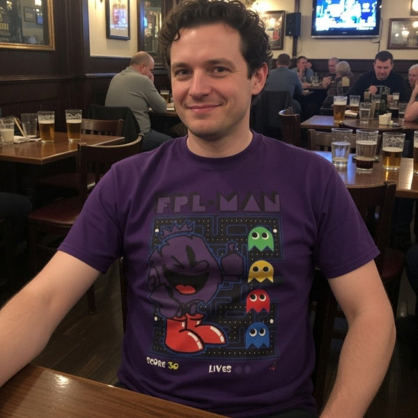 Man wearing a purple t-shirt with a Pac-Man design in a pub setting