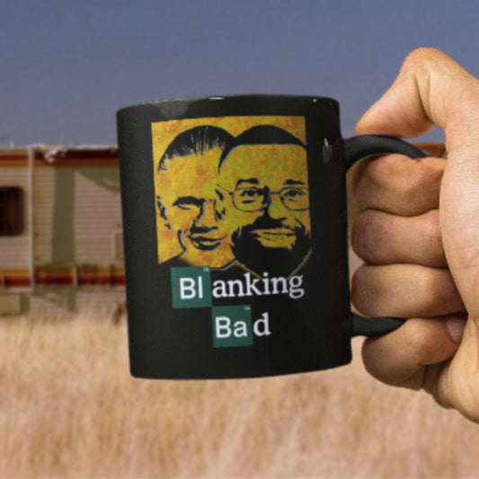 black mug that reads 'Blanking Bad' being held by hand in the dessert