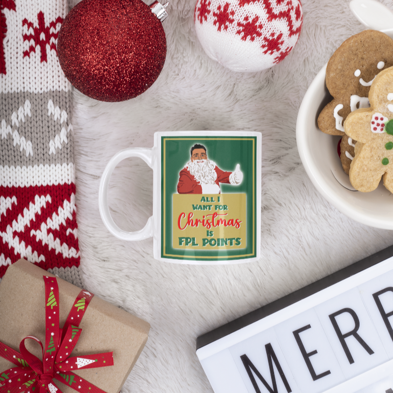 Christmas-themed mug with Santa Claus design, surrounded by festive items like ornaments and cookies.