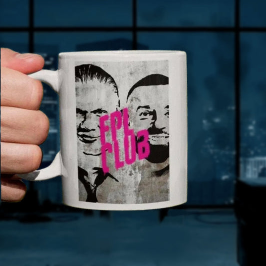 Person holding a mug with a graphic design of two faces and 'FPL CLUB' text against a blue room.