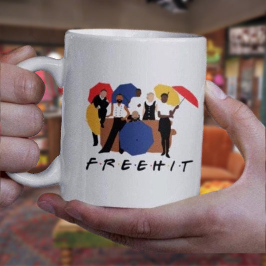 Person holding a white mug with a colorful graphic and 'FREEHIT' text