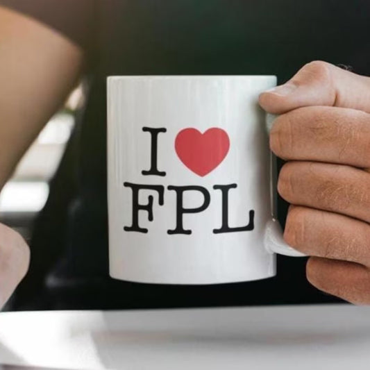 Person holding a white mug with 'I ❤️ FPL' text, likely referring to a football fantasy league.