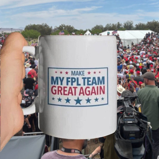 Person holding a mug with 'Make My FPL Team Great Again' text at a crowded outdoor event.