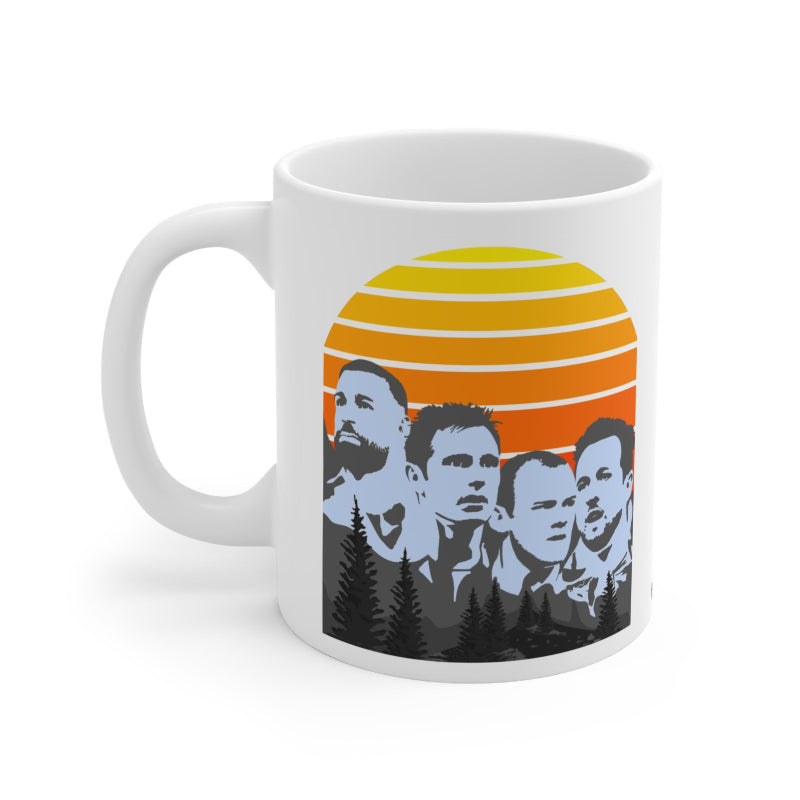 White mug with a design of five silhouettes against an orange sunset background