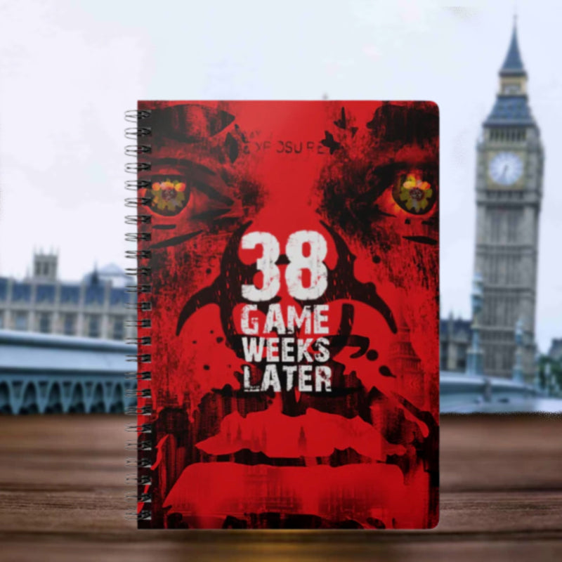 Notebook with a red cover featuring text and a graphic design, set against a blurred background with a clock tower.