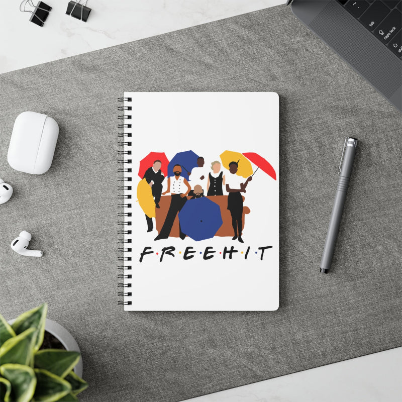 Notebook with colorful design and 'FREEHIT' text on a desk with a pen and airpods.