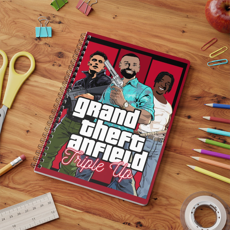 Notebook with 'Grand Theft Anfield' design on a wooden surface with stationery items.