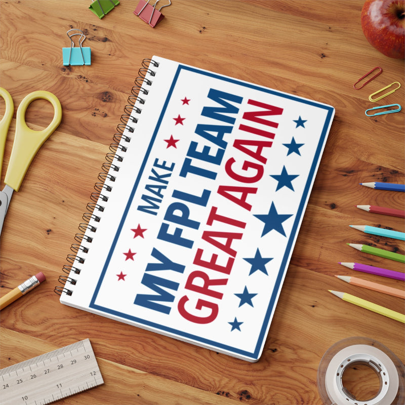 Notebook with 'Make My FPL Team Great Again' on a wooden desk with stationery items.