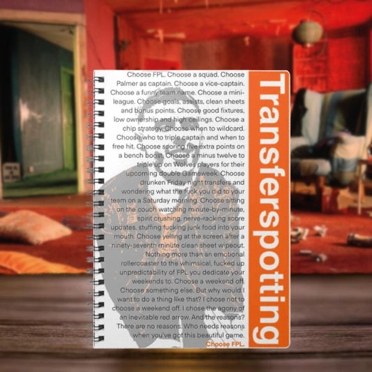 Notebook with 'Transferspotting' branding on a blurred indoor background
