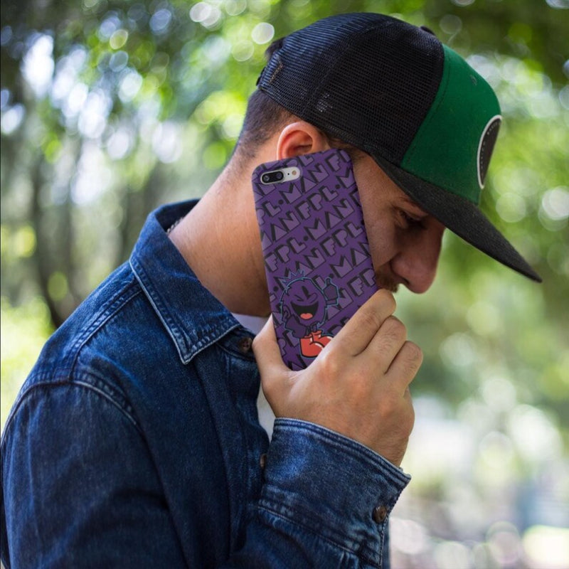 Person holding a purple phone case with a pattern, wearing a black and green cap outdoors.