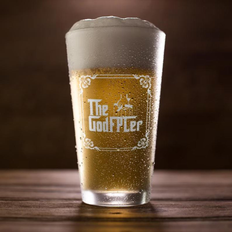 Pint of beer with foam and 'The GodFPLer' branding on a wooden surface.