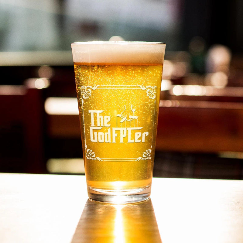 Pint glass of beer with 'The GodFPLer' branding on a blurred bar background