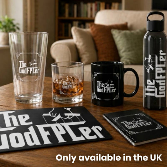 The GodFPLer FPL prize bundle with pint glass, rocks glass, mug, water bottle, notebook and desk mat on a coffee table