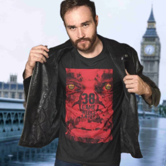 Man wearing a black t-shirt with a red graphic design in front of a blurred cityscape with a clock tower.