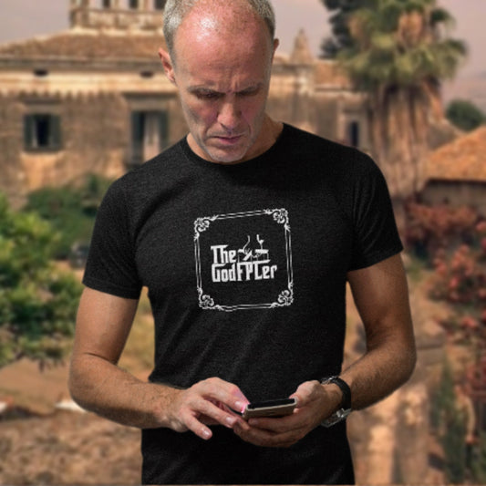 Man wearing a black t-shirt with 'The GodFPLer' logo, standing outdoors with a blurred background