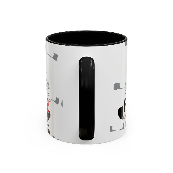 A white ceramic mug with a black interior, black handle, and a minimalist graphic print featuring a black cat and gray cat toys on the side.