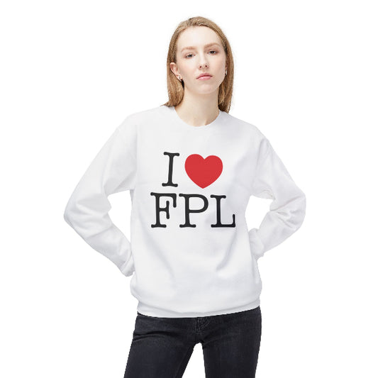A woman modeling a white crewneck sweatshirt with a graphic print that reads 'I [red heart] FPL' in black text, paired with black jeans, against a plain white background.