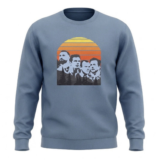 A dusty blue crewneck sweatshirt featuring a retro-style graphic print of four men's faces in black and white, set against a yellow, orange, and red sunset background.