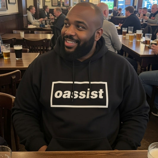 Man wearing a black hoodie with 'oassist' logo in a pub setting