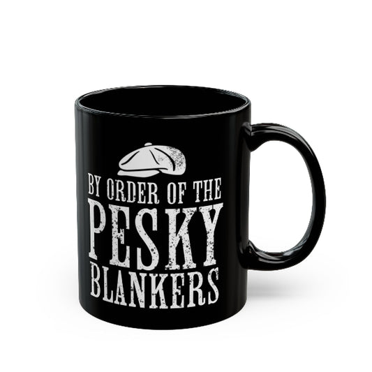 A glossy black ceramic mug with a white distressed typographic design reading 'BY ORDER OF THE PESKY BLANKERS' and a small flat cap graphic above, shown on a clean white background.