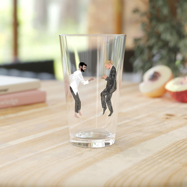 Clear glass with miniature figures of two men on a wooden surface