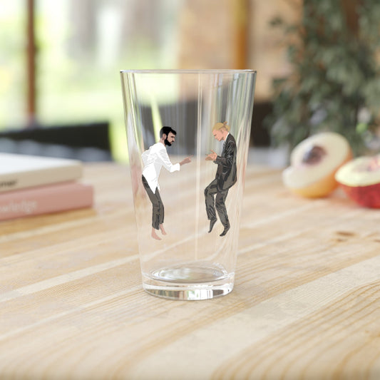 Clear glass with miniature figures of two men on a wooden surface