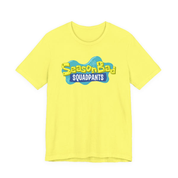 A bright yellow short-sleeve crewneck t-shirt featuring a 'Season Bad SQUADPANTS' graphic on the chest, displayed against a solid white background.