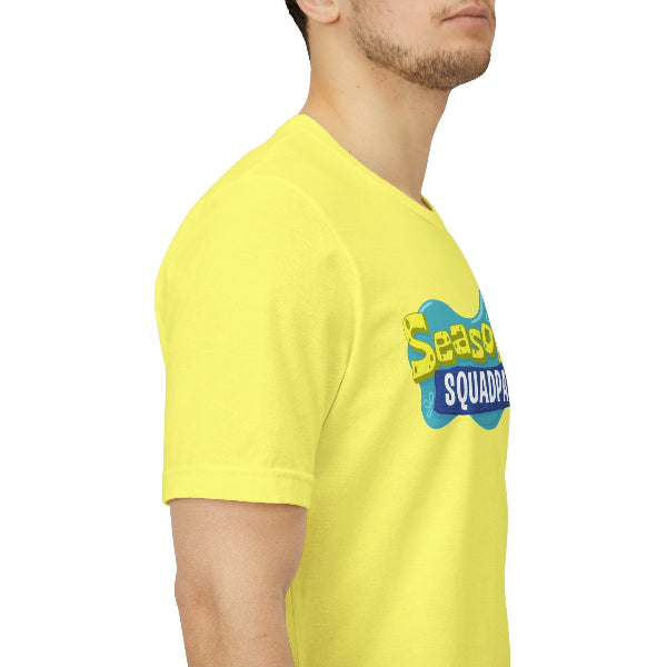 A man wearing a bright yellow t-shirt with a blue and yellow 'Season 1 SQUADPAW' graphic on the chest, shown in a side-profile view against a white background.