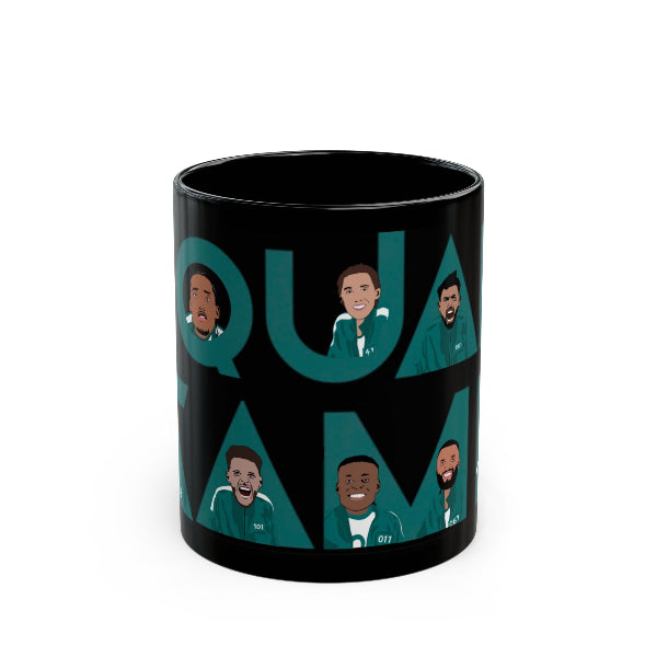 Black mug with cartoon characters and 'QUA DAM' text on a white background