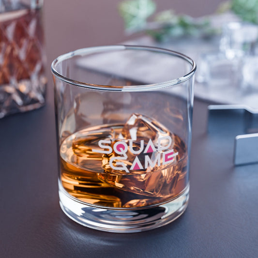 Glass of whiskey with 'SQUAD GAME' text on a table