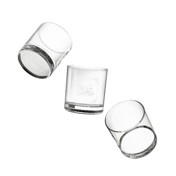 Set of four clear glass tumblers with gold geometric patterns on a white background
