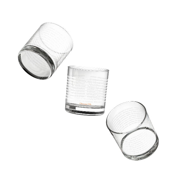 Set of four clear glass tumblers with gold geometric patterns on a white background
